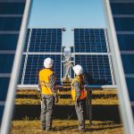 two workers at solar panel station